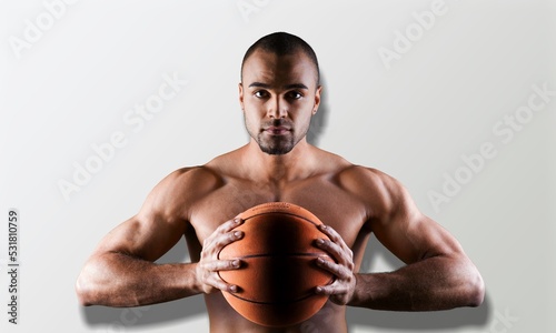 Young male basketball player holding ball, sports lifestyle concept. © BillionPhotos.com