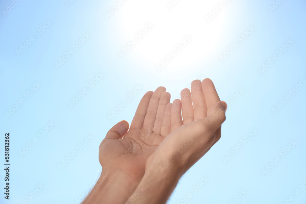Man reaching hands to blue sky outdoors on sunny day, closeup Man reaching hands to blue sky outdoors on sunny day, closeup