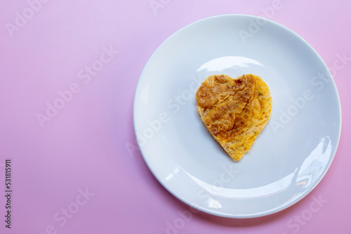 Today I made a heart-shaped omelet on a white plate. Then put it on the pink table.