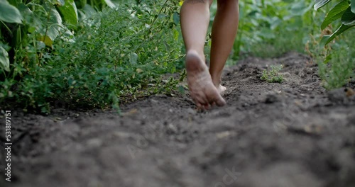 Girl walking barefoot through rich soil