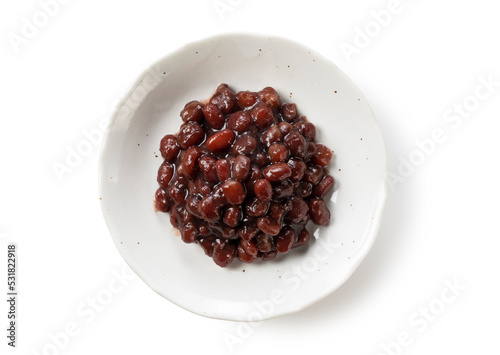 Boiled azuki beans in a dish placed on a white background.