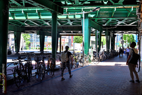 新橋駅ガード下の駐輪場と歩行者シルエット photo