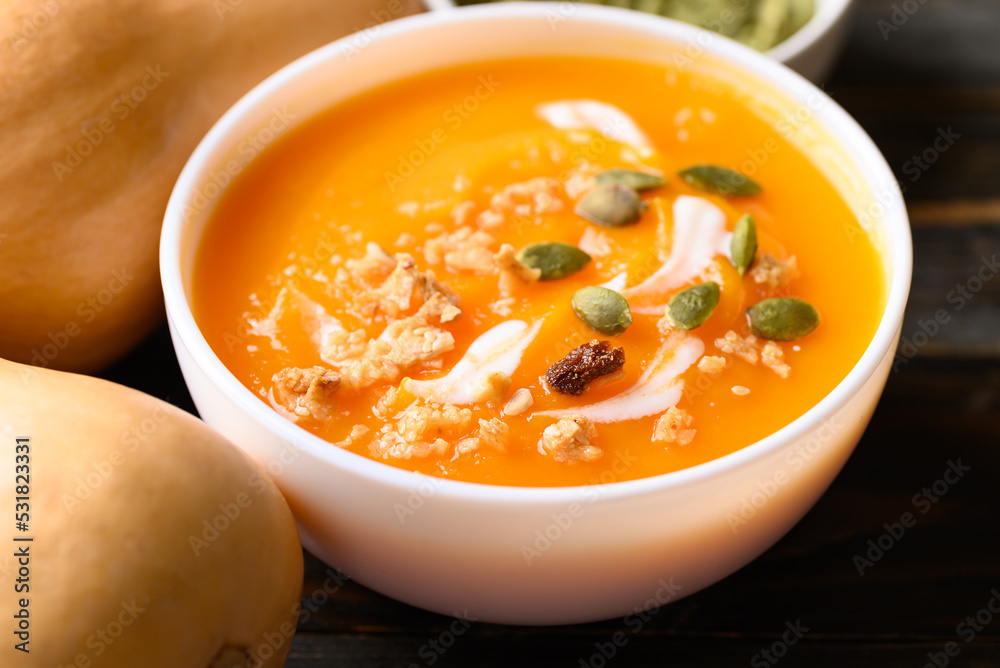 Butternut squash pumpkin soup in bowl on wooden background, Homemade food in autumn season Butternut squash pumpkin soup in bowl on wooden background, Homemade food in autumn season