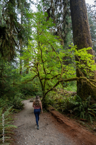 Young woman on Hoh Rain Forest trail in Olympic National Park, Washington on overcast autumn morning..