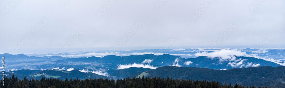 a view of the valley and the mountains shrouded in fog

