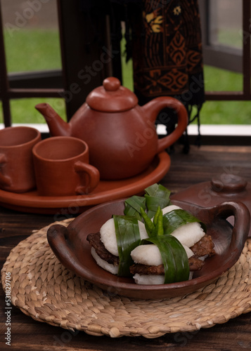 Jadah Tempe, food made from finely mashed glutinous rice and fried soy tempe. Traditional snacks for local afternoon tea time. On traditional plate. Selective Focus photo