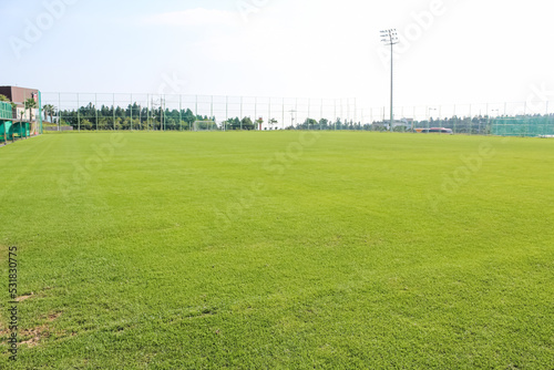 A view of the soccer driving range on a clear day. grass field.