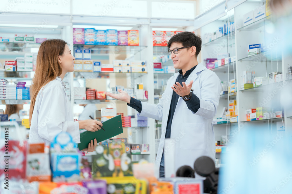 Male and female pharmacists talk to check stocks of medicines in pharmacies. communication