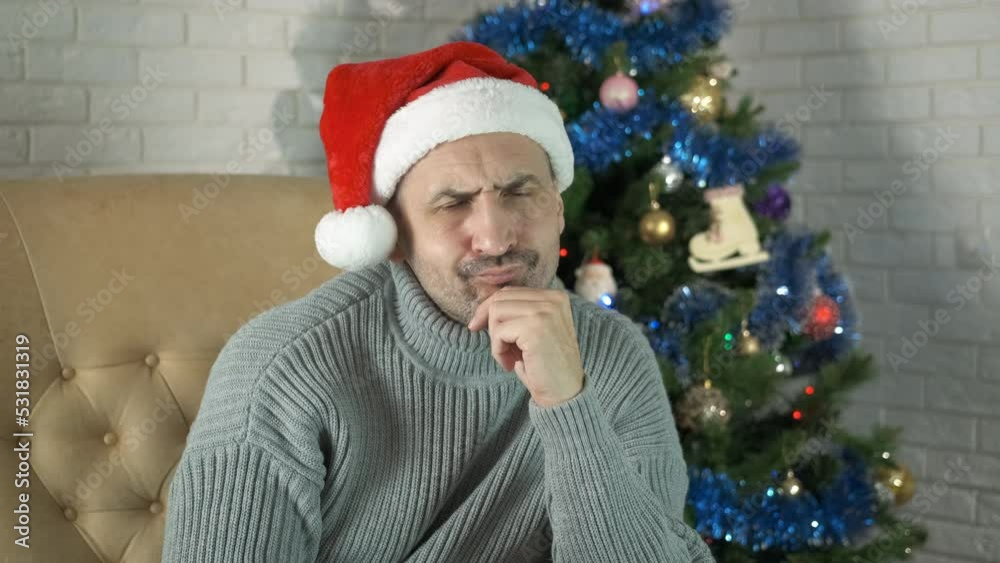 Man feel frustrated at Christmas. A man feel frustrated during Christmas time by the decorated tree. Man feel frustrated at Christmas. A man feel frustrated during Christmas time by the decorated tree.