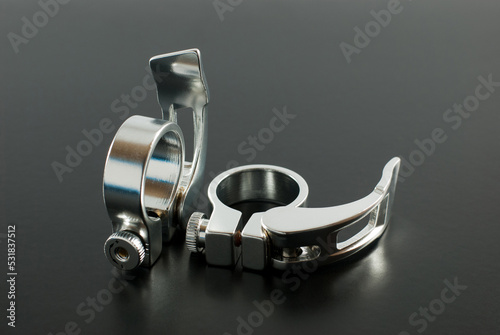 Silver alloy quick release seatpost clamp, bicycle spare parts, on a black background. photo