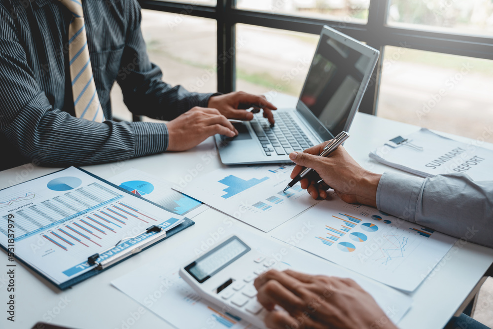 Two businessman working together to plan investment at the meeting. Close-up of businessman advisor pointing to graph and chart, analyzes financial report and profit deficit. Two businessman working together to plan investment at the meeting. Close-up of businessman advisor pointing to graph and chart, analyzes financial report and profit deficit.
