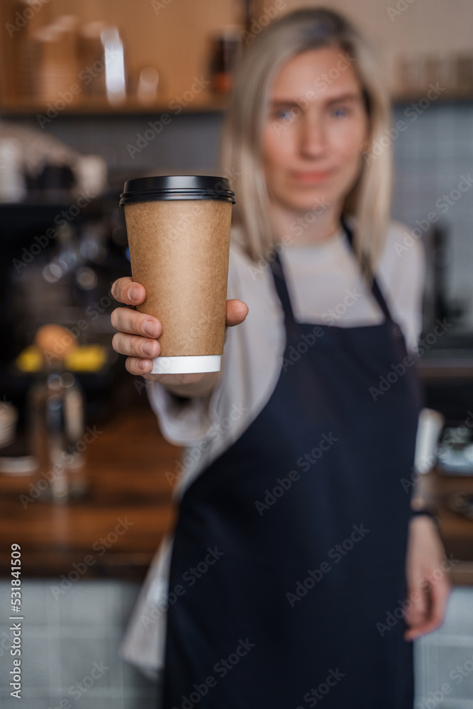 Shot of aged female barman working in coffee shop with blond hairs and coffee cup. Shot of aged female barman working in coffee shop with blond hairs and coffee cup.