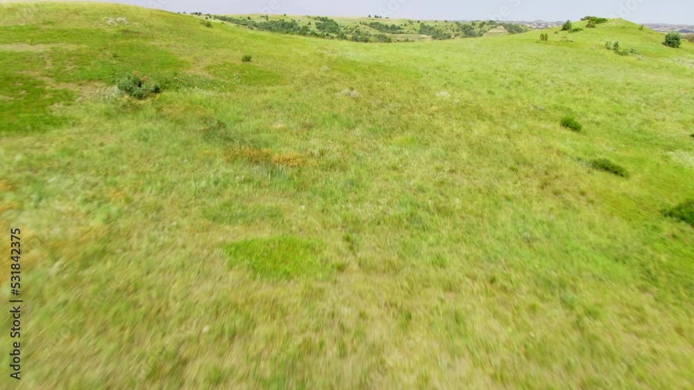 Aerial Flyover Cowboy riding on horseback in a large open field with rolling hills in the background Aerial Flyover Cowboy riding on horseback in a large open field with rolling hills in the background