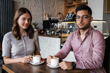 Shot of man with his girlfriend relaxing drinking coffee in modern coffee shop.