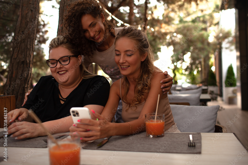 Group of female friends, plus size with thin girls sit in cafe and drink the drinks. Group of female friends, plus size with thin girls sit in cafe and drink the drinks.