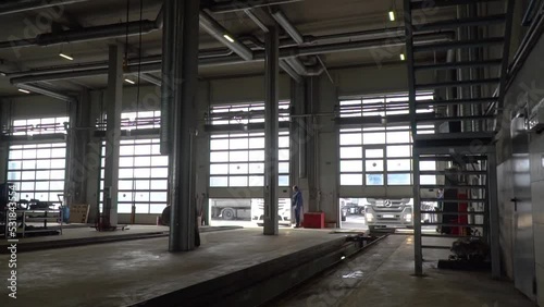 Truck service station with trucks and refrigerators. the gates rise.Panorama at the service station of trucks with semi-trailers and refrigerators. Lorry are in the truck service on the inspection pit