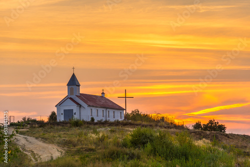 A small chapel on a hill at sunset time