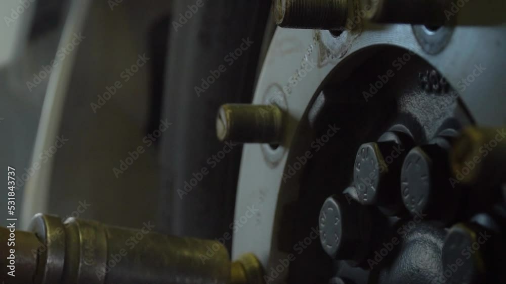 close-up. A professional mechanic uses a pneumatic wrench to unscrew refrigerator truck wheel nut at a truck service station. Repair: car wheel installation, bolt tightening. close-up. A professional mechanic uses a pneumatic wrench to unscrew refrigerator truck wheel nut at a truck service station. Repair: car wheel installation, bolt tightening.