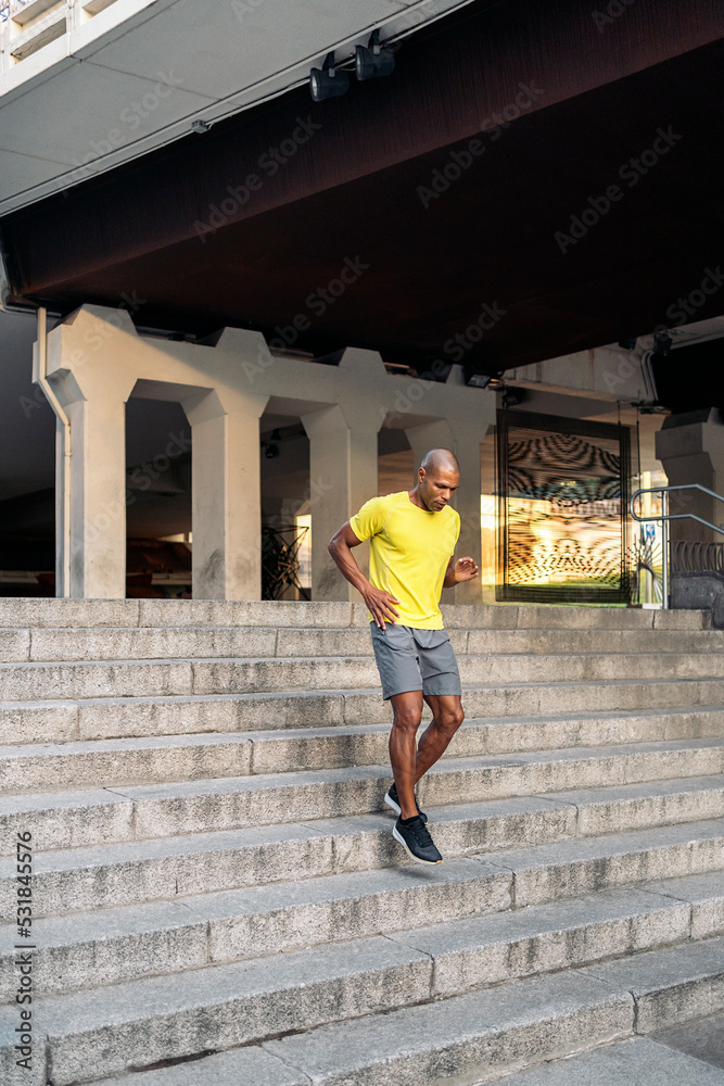 Sportsman jogging down on stairs outside