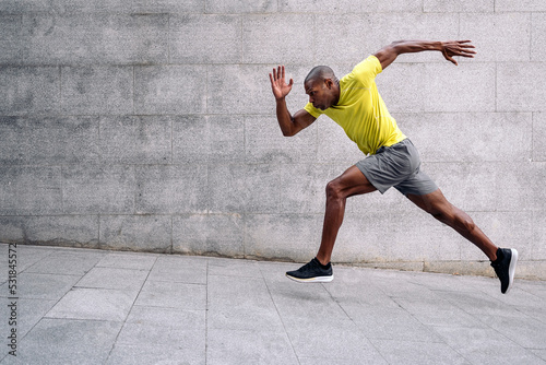 African American sportsman sprinting up on inclined floor outdoors