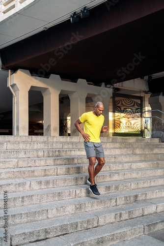 Sportsman jogging down on stairs outside