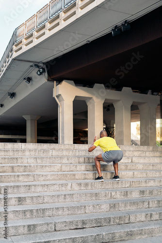 Wallpaper Mural Unrecognizable adult man doing squats exercises on stairs outdoor Torontodigital.ca