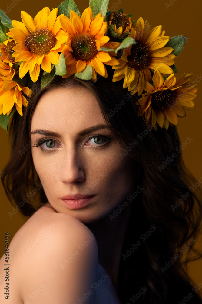 Fototapeta premium Portrait of a Ukrainian girl in a wreath of colorful yellow sunflowers. National traditional flower headdress. Ukraine concept. Stop war