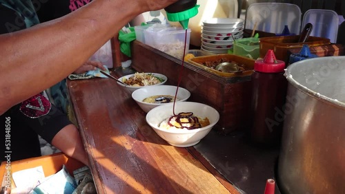 Chicken porridge seller preparing customer orders. Traditional porridge breakfast menu