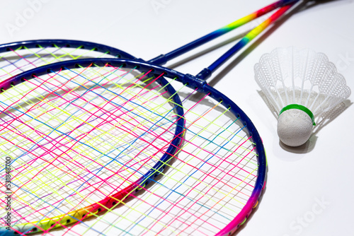 Selective focus colorful badminton rackets and plastic shuttlecock on isolated white background. Game, sport, fun concept. © CONQUEROR