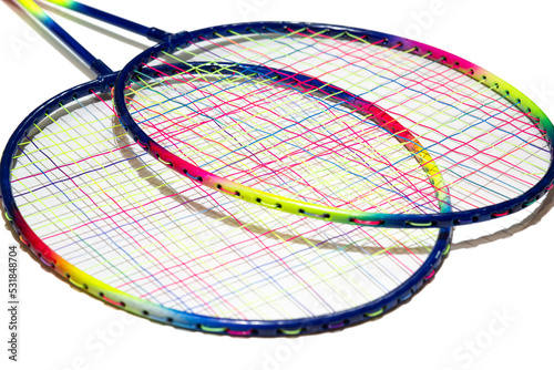 Colorful badminton rackets on isolated white background with selective focus. Game, sport, fun concept.