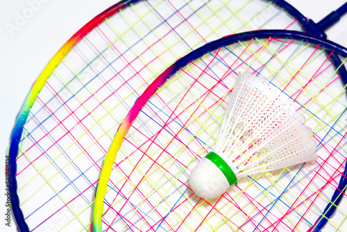 Colorful badminton rackets and shuttlecock in selective focus on isolated white background. © CONQUEROR