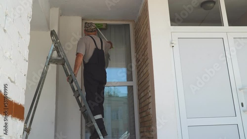 Wallpaper Mural A man window cleaner on a stepladder washes the window with a rag on a mop Torontodigital.ca
