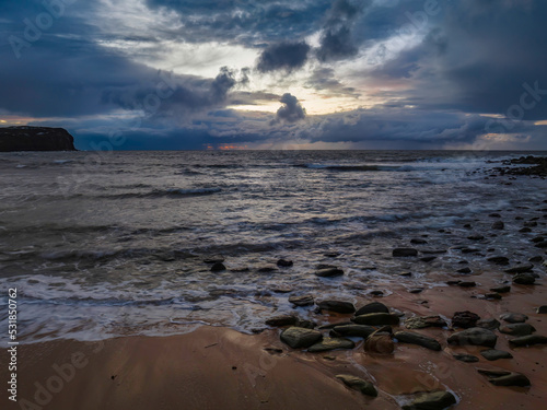 Fototapeta Naklejka Na Ścianę i Meble -  Moody sunrise seascape with rain clouds