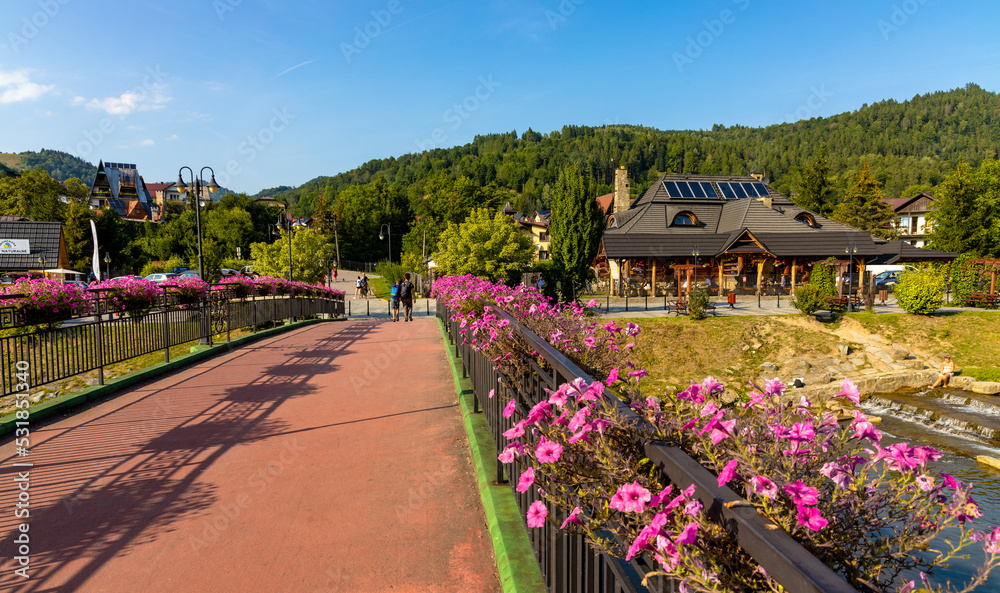 Obraz premium Most Michala Slowika Dzwona Bridge over Grajcarek creek in Szczawnica Zdroj springs resort in Pieniny Mountains in Lesser Poland