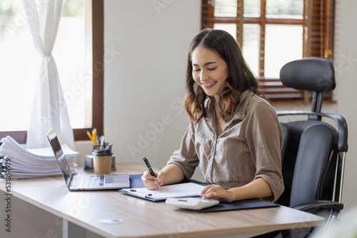 Asian businesswoman Accounting using calculating income-expenditure and analyzing real estate investment data report Financial and tax systems in workplace an home office. © David