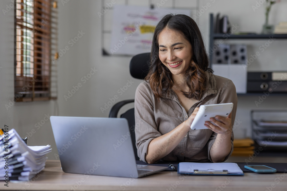 Asian businesswoman Accounting using calculating income-expenditure and analyzing real estate investment data report Financial and tax systems in workplace an home office. Asian businesswoman Accounting using calculating income-expenditure and analyzing real estate investment data report Financial and tax systems in workplace an home office.
