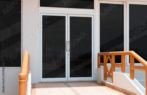 Entrance blank glass door with metal handles.