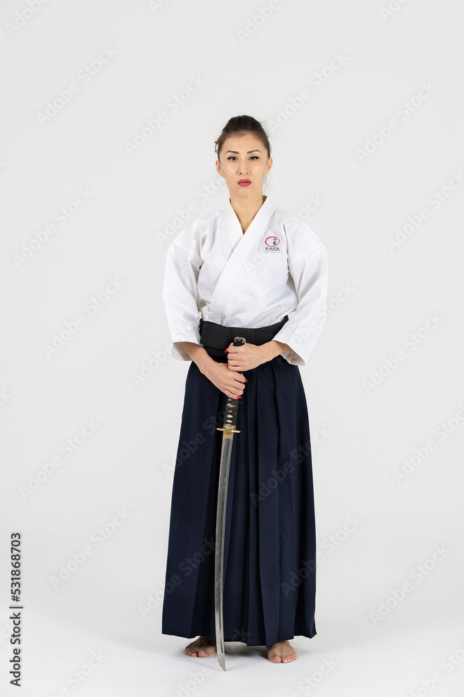 Aikido master woman in traditional samurai hakama kimono with black belt  with sword, katana on white background. Healthy lifestyle and sports  concept. Stock Photo | Adobe Stock