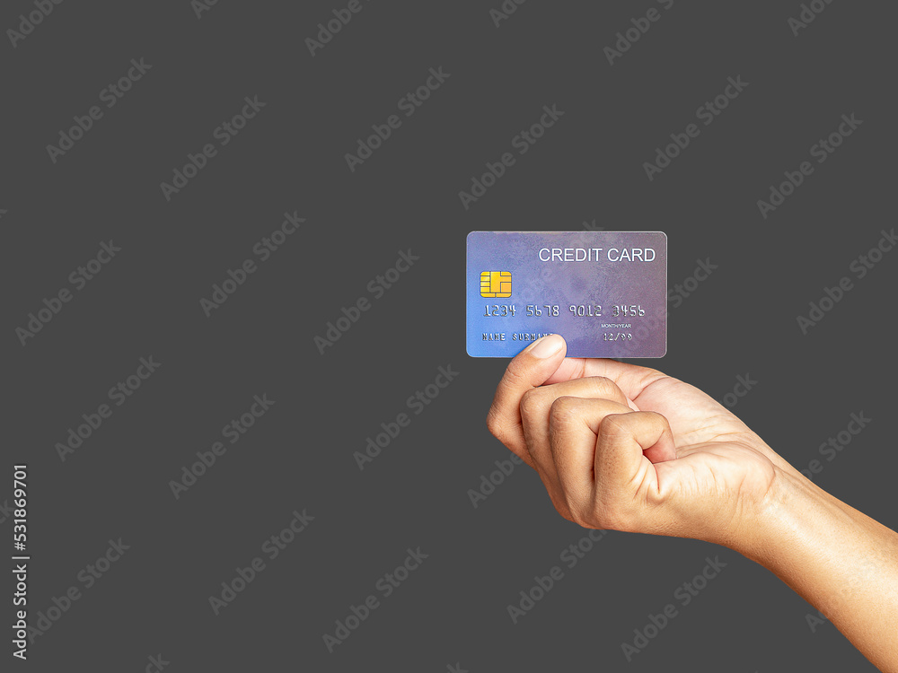 Hand of holding a mockup blue credit card while standing with gray background Hand of holding a mockup blue credit card while standing with gray background