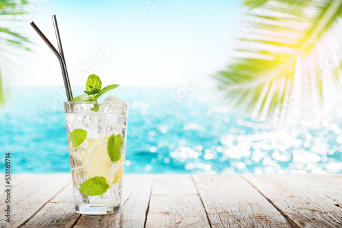Fototapeta Naklejka Na Ścianę i Meble -  Mojito cocktail on wooden table in front of sunny sea