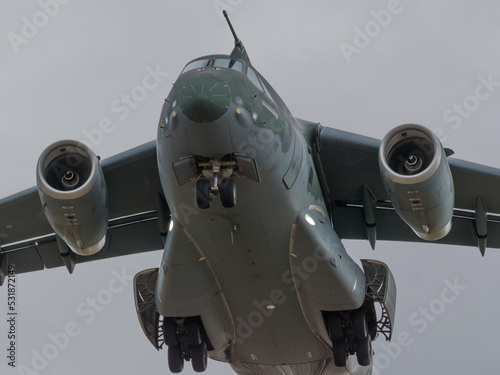 avion de transporte militar propulsado a reaccion aterrizando en un dia gris photo