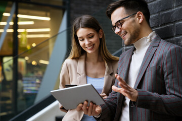 Two creative business people working on social media strategy using a digital tablet