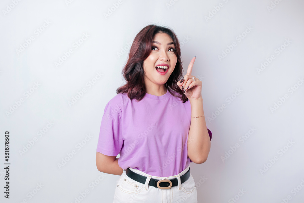 Fototapeta premium Portrait of a thoughtful young casual girl wearing a lilac purple shirt looking aside isolated over white background