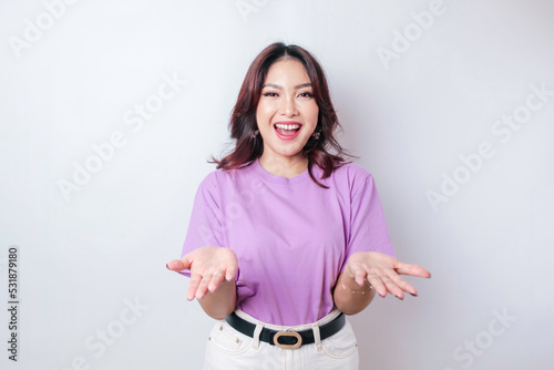 Young Asian woman presenting an idea while looking smiling on isolated white background
