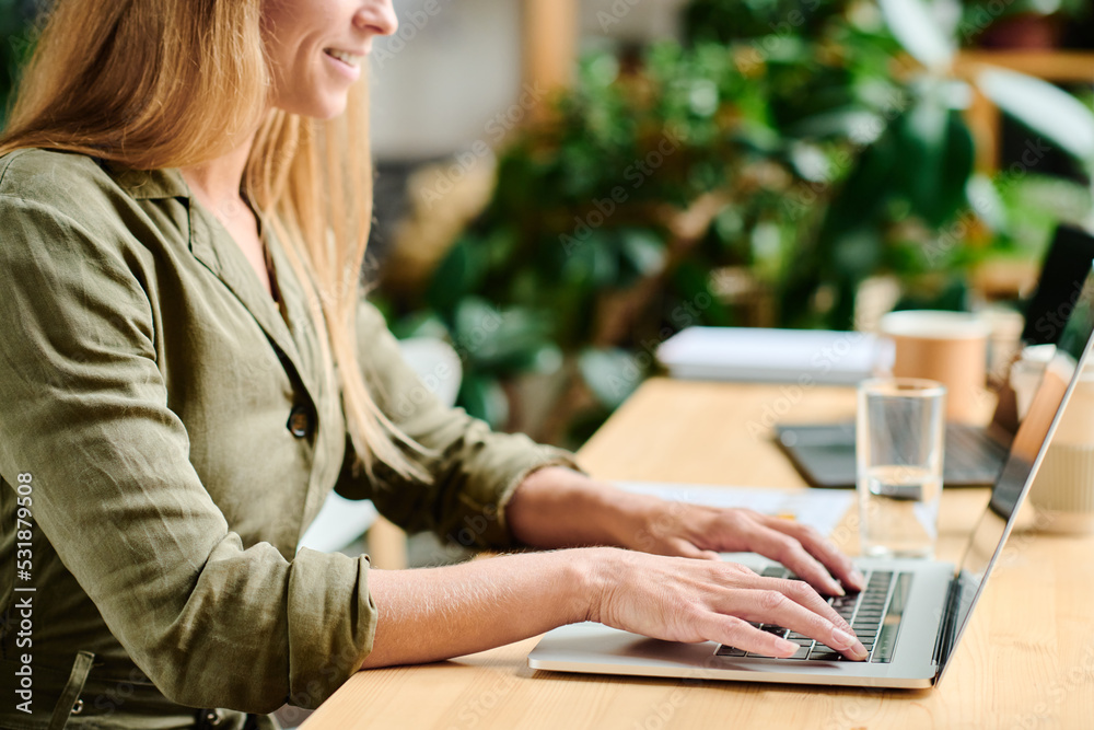 © pressmaster - Close-up of young female freelancer in casualwear touching buttons of laptop keypad while sitting by table in cafe or modern office © pressmaster - Close-up of young female freelancer in casualwear touching buttons of laptop keypad while sitting by table in cafe or modern office