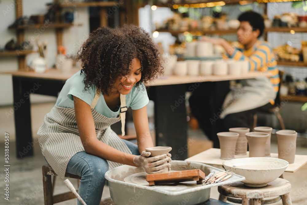 Φωτογραφία Creative afro American young woman artist molding clay on pottery wheel, Worksho