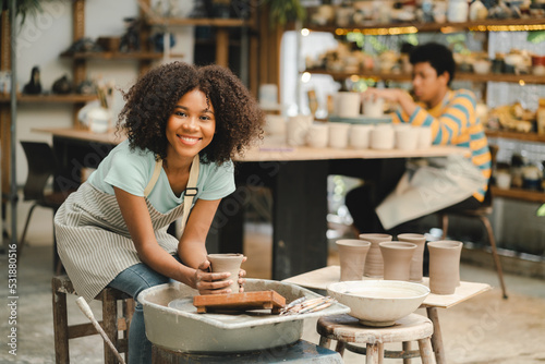 Obraz na płótnie Creative afro American young woman artist molding clay on pottery wheel, Worksho