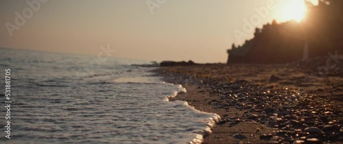 Waves of beach hitting the shores during a beautiful sunset photo