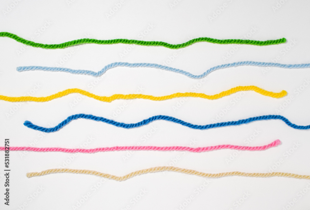 Colorful yarn thread line on white background.