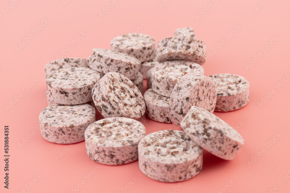 Heap of medicine colored pills, tablets on a pink background Heap of medicine colored pills, tablets on a pink background
